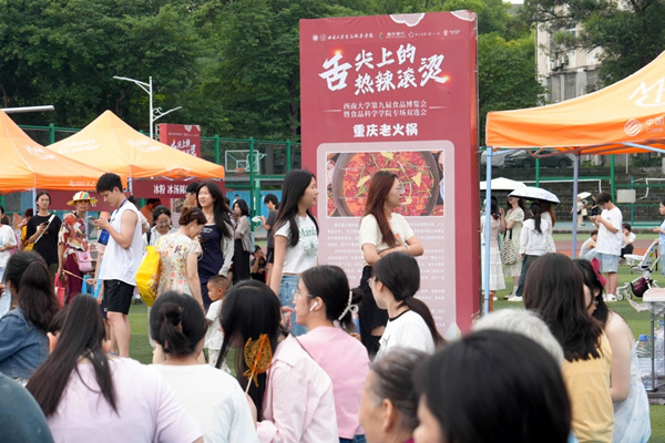 学生在活动现场一边品尝美食，一边寻找工作。秦廷富摄